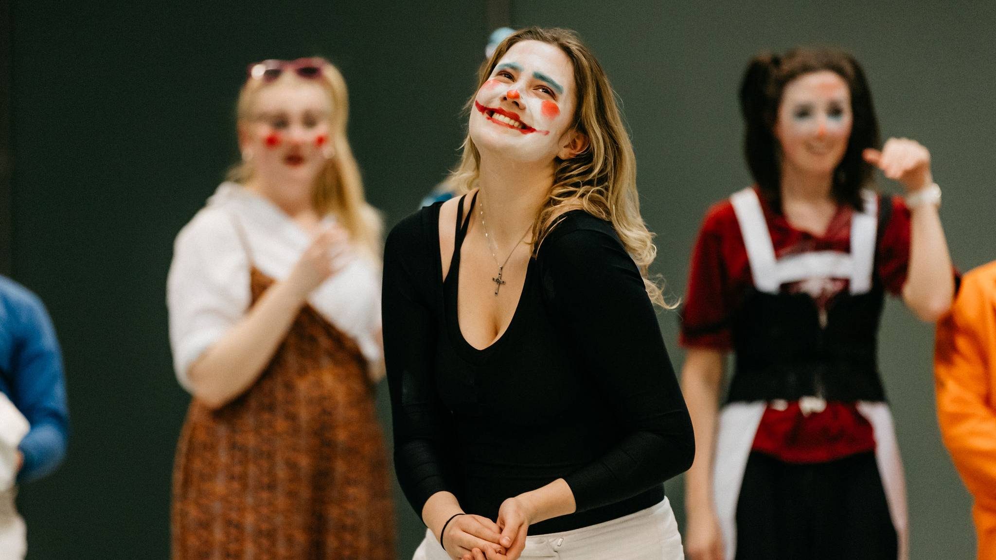 A group of students perform wearing clown make up