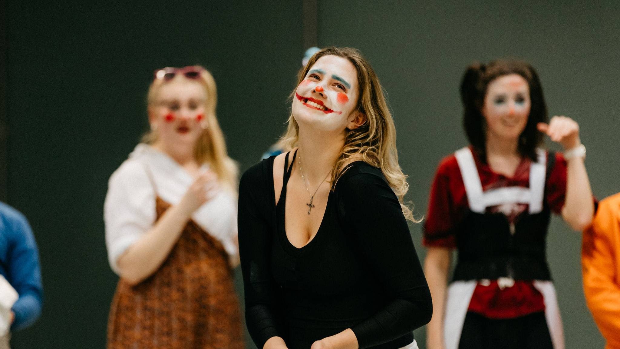 A group of students perform wearing clown make up