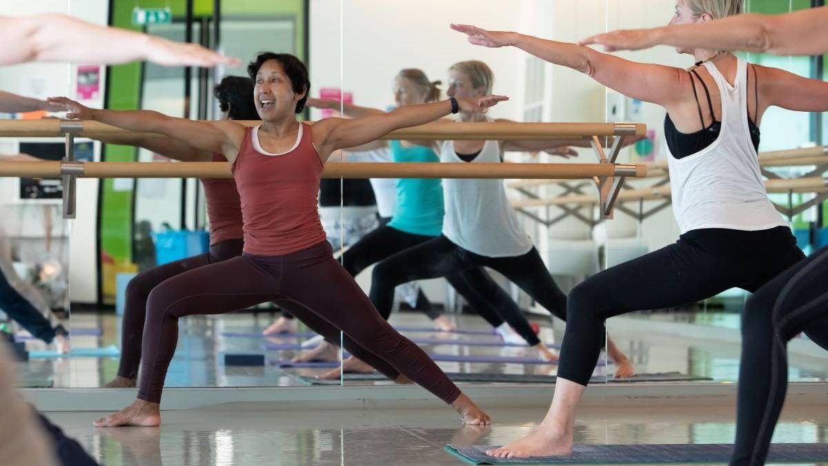 warrior pose yoga teacher during adult class