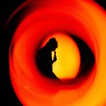 Silhouette of someone singing into a microphone.