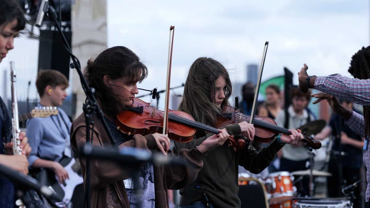Young Musicians' Summer School, a band featuring two violin players perform on stage at the old royal naval college