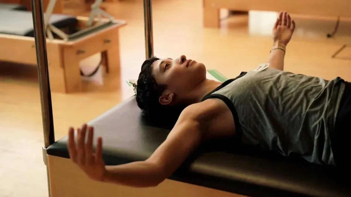 Dance Science student lying down on a bench with their arms spread out to the side